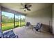 Screened in patio with ceiling fan and outdoor seating overlooks a green backyard at 12937 Ogden Glade Rd, Dade City, FL 33525