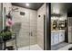 Modern shower with glass doors and sleek fixtures next to a stylish bathroom with wood-look tile floors at 12937 Ogden Glade Rd, Dade City, FL 33525