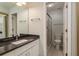 The bathroom has a large mirror, a vanity with granite countertops, and a shower with sliding glass doors at 1380 Azalea Dr # 1701, Dunedin, FL 34698
