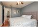 The bedroom is painted a soft gray, has wood floors and includes white bedding with blue accents at 1380 Azalea Dr # 1701, Dunedin, FL 34698