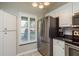 Kitchen featuring stainless steel appliances, white cabinets, and tile backsplash at 1380 Azalea Dr # 1701, Dunedin, FL 34698