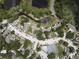 Aerial view of neighborhood showcasing tennis court, pool, ponds, mature trees, parking, and roadways at 13907 Fletchers Mill Dr, Tampa, FL 33613