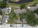 Aerial view of a residential area with houses, trees, pond and a parking lot full of cars at 13907 Fletchers Mill Dr, Tampa, FL 33613