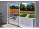 View through sliding glass doors onto a spacious backyard with patio, seating, and a fire pit at 13907 Fletchers Mill Dr, Tampa, FL 33613