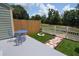 Outdoor living space with patio, seating area, fire pit, wooden fence, and lush landscaping at 13907 Fletchers Mill Dr, Tampa, FL 33613