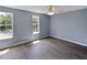 Spacious bedroom with natural light, ceiling fan, and wood-look flooring at 13907 Fletchers Mill Dr, Tampa, FL 33613