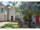 Townhouse featuring a quaint front yard, mature palm trees and neutral two-tone paint scheme at 13907 Fletchers Mill Dr, Tampa, FL 33613