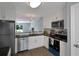 Bright kitchen featuring white cabinets, stainless steel appliances, and granite countertops at 13907 Fletchers Mill Dr, Tampa, FL 33613