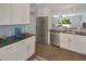 Spacious kitchen with stainless steel appliances and modern white cabinetry, open to the living area at 13907 Fletchers Mill Dr, Tampa, FL 33613