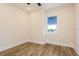 Cozy bedroom featuring wood-look flooring, a window with blue blinds, and white trim at 1413 Bayshore Blvd # 11, Dunedin, FL 34698