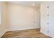 Bright bedroom featuring wood-look flooring, neutral paint, and a large doorway to the hallway at 1413 Bayshore Blvd # 11, Dunedin, FL 34698