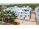 Stunning exterior view of townhomes with white roofs, light blue facades and charming blue awnings at 1413 Bayshore Blvd # 11, Dunedin, FL 34698