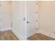 Hallway with wood-look floors, white trim, and a closed white door at 1413 Bayshore Blvd # 11, Dunedin, FL 34698