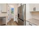 The kitchen features stainless steel appliances and white cabinets, next to a pantry with open shelving at 1413 Bayshore Blvd # 11, Dunedin, FL 34698