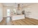 Bright kitchen features white cabinets, an island with cooktop, stainless steel appliances and wood floors at 1413 Bayshore Blvd # 11, Dunedin, FL 34698