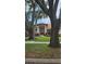 Charming home with manicured lawn and mature trees creating a welcoming atmosphere at 16502 Windsor Park Dr, Lutz, FL 33549