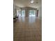 Expansive living room with tile flooring and access to outdoor pool area through sliding glass doors at 16502 Windsor Park Dr, Lutz, FL 33549