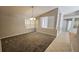 Open-concept living room featuring neutral walls, plush carpet, and a chandelier over a large window for abundant natural light at 16502 Windsor Park Dr, Lutz, FL 33549
