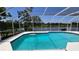 Sparkling screened-in pool with picturesque views of the adjacent lake at 16502 Windsor Park Dr, Lutz, FL 33549