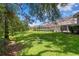 Large backyard featuring manicured lawn and screened in lanai at 17818 Arbor Greene Dr, Tampa, FL 33647
