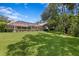 Expansive backyard featuring mature trees, lush lawn, and screened in lanai at 17818 Arbor Greene Dr, Tampa, FL 33647