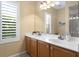 Bathroom boasts a glass shower, double sink, and a window with plantation shutters at 17818 Arbor Greene Dr, Tampa, FL 33647