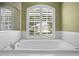 Close up on bathtub with shuttered window at 17818 Arbor Greene Dr, Tampa, FL 33647