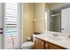 Well-lit bathroom features a tiled shower, wood vanity, and access to the outdoor pool area at 17818 Arbor Greene Dr, Tampa, FL 33647