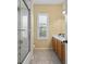 Bathroom boasts a glass shower, double sink, and a window with plantation shutters at 17818 Arbor Greene Dr, Tampa, FL 33647