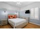 Cozy bedroom featuring stylish decor with a ceiling fan, a large window, and charming wall sconces at 17818 Arbor Greene Dr, Tampa, FL 33647