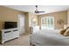 Comfortable bedroom featuring a door with shutters, a TV, and a large window with pool view at 17818 Arbor Greene Dr, Tampa, FL 33647