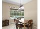 Charming dining area with views of the pool through the window and an elegant hanging light at 17818 Arbor Greene Dr, Tampa, FL 33647