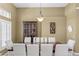 Elegant dining room with a large table, white chairs, and a decorative light fixture at 17818 Arbor Greene Dr, Tampa, FL 33647