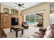 Cozy living room with a ceiling fan, a stylish built-in cabinet, and a view of the backyard at 17818 Arbor Greene Dr, Tampa, FL 33647