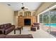 Living room with access to the pool area through large sliding glass doors and ceiling fan at 17818 Arbor Greene Dr, Tampa, FL 33647