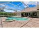 Enclosed pool area with hot tub and patio near outdoor kitchen and living space at 17818 Arbor Greene Dr, Tampa, FL 33647