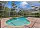 Enclosed pool area complete with a hot tub, brick patio, and screened enclosure at 17818 Arbor Greene Dr, Tampa, FL 33647