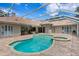 Enclosed pool area with hot tub, brick patio, and partial view of home's exterior at 17818 Arbor Greene Dr, Tampa, FL 33647