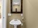Well-appointed powder room with pedestal sink and decorative mirror at 17818 Arbor Greene Dr, Tampa, FL 33647