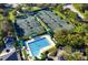 Aerial view of community with tennis courts and a sparkling blue community pool at 17818 Arbor Greene Dr, Tampa, FL 33647