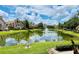 Scenic pond reflecting the blue sky and surrounding buildings, with lush green grass in foreground at 17942 Villa Creek Dr # 17942, Tampa, FL 33647