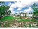 Large backyard featuring a wooden pergola, raised garden beds, and mature trees at 2060 Saffold Park Dr, Ruskin, FL 33570