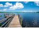 Scenic view of the wooden dock on the water with blue sky and puffy white clouds above at 2060 Saffold Park Dr, Ruskin, FL 33570