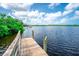Scenic view of the wooden dock on the water with blue sky and puffy white clouds above at 2060 Saffold Park Dr, Ruskin, FL 33570