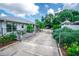 Long concrete driveway leading to a gated backyard featuring vibrant flowers and landscape alongside the house at 2060 Saffold Park Dr, Ruskin, FL 33570