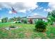Quaint single-story home featuring a metal roof, green lawn, landscaping, and an American flag waving proudly at 2060 Saffold Park Dr, Ruskin, FL 33570