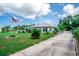 Charming single-story home featuring a metal roof, lush lawn, and an American flag waving proudly at 2060 Saffold Park Dr, Ruskin, FL 33570