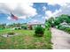 Quaint single-Gathering house with a metal roof, green lawn, landscaping, and an American flag waving proudly at 2060 Saffold Park Dr, Ruskin, FL 33570