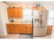 Bright kitchen boasts stainless steel refrigerator, wooden cabinets, and double sink at 2060 Saffold Park Dr, Ruskin, FL 33570
