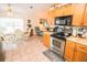 Open kitchen boasts wooden cabinetry, stainless steel appliances, and adjacent dining area at 2060 Saffold Park Dr, Ruskin, FL 33570